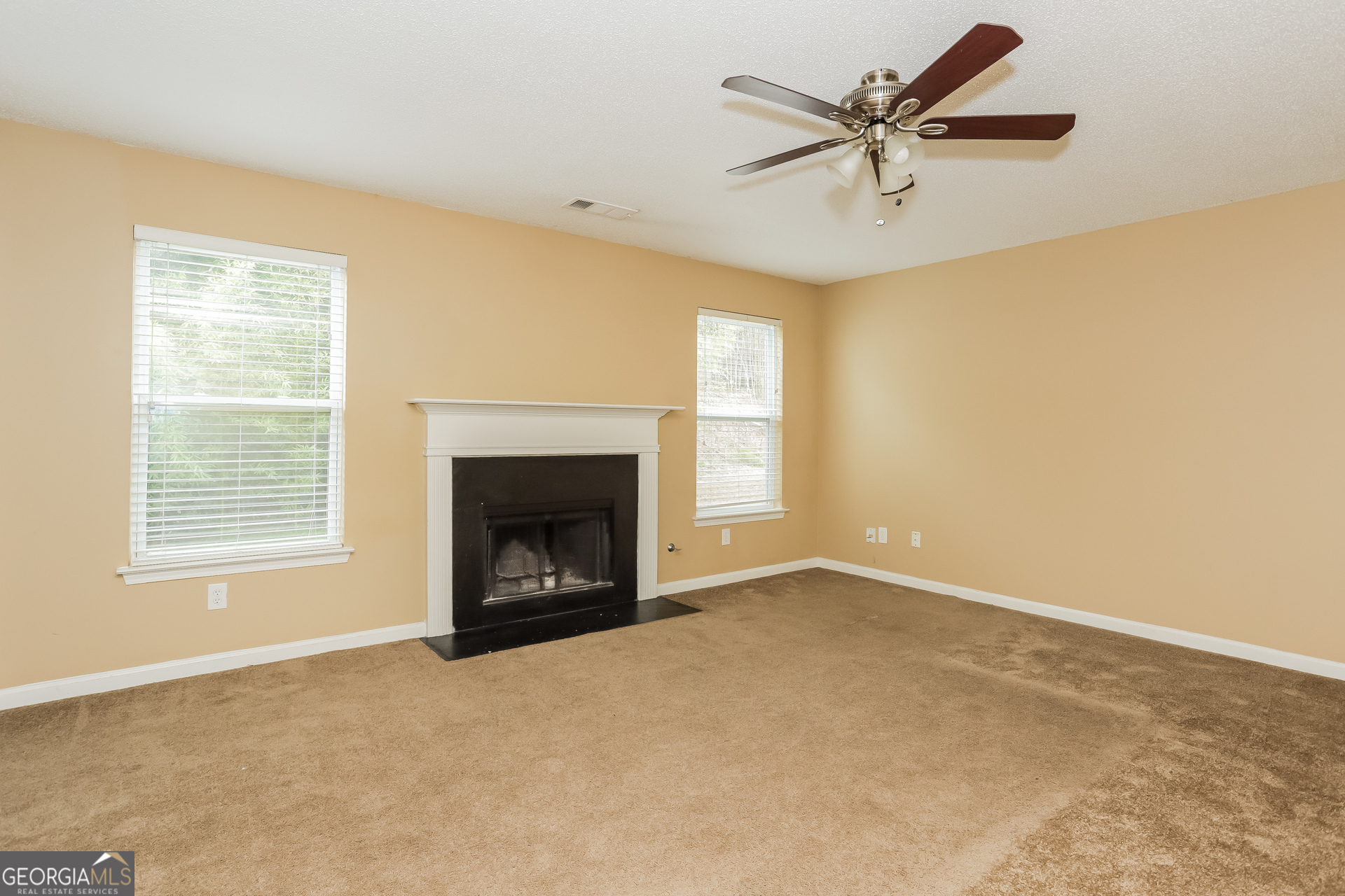 5002 Serenity Point Lane Villa Rica, GA 30180 - Photo 2 of 17 an empty room with a fireplace and a ceiling fan