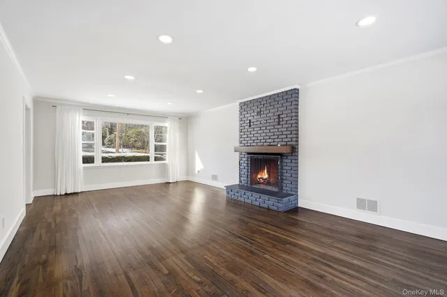 an empty room with wooden floor and fireplace