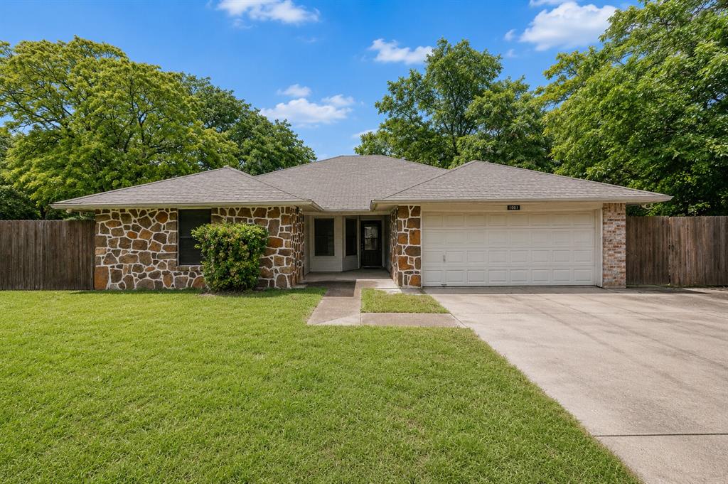 1001 Rosebud Drive Azle, TX 76020 - Photo 1 of 36 Exterior featuring a stone and brick facade, an attached two-car garage, a concrete driveway, a manicured lawn, and a privacy fence