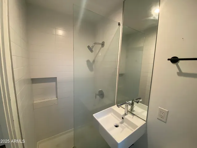 a bathroom with a sink mirror and shower