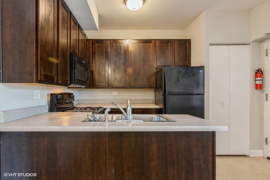 6853 South Ridgeland Avenue, Unit 402 Chicago, IL 60649 - Photo 2 of 6 a kitchen with a sink and a refrigerator