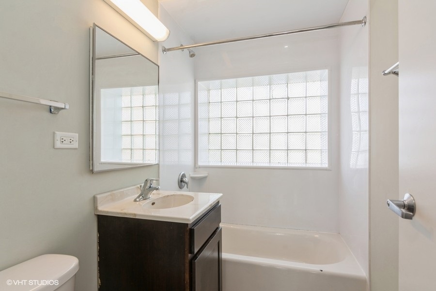 6853 South Ridgeland Avenue, Unit 402 Chicago, IL 60649 - Photo 6 of 6 a bathroom with a sink toilet and shower