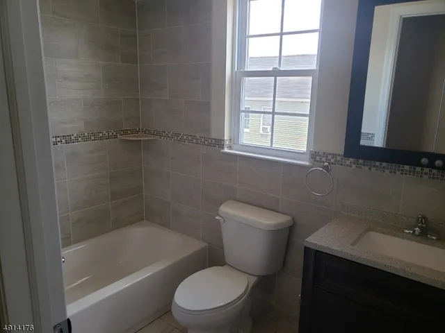 a white toilet sitting next to a bath tub