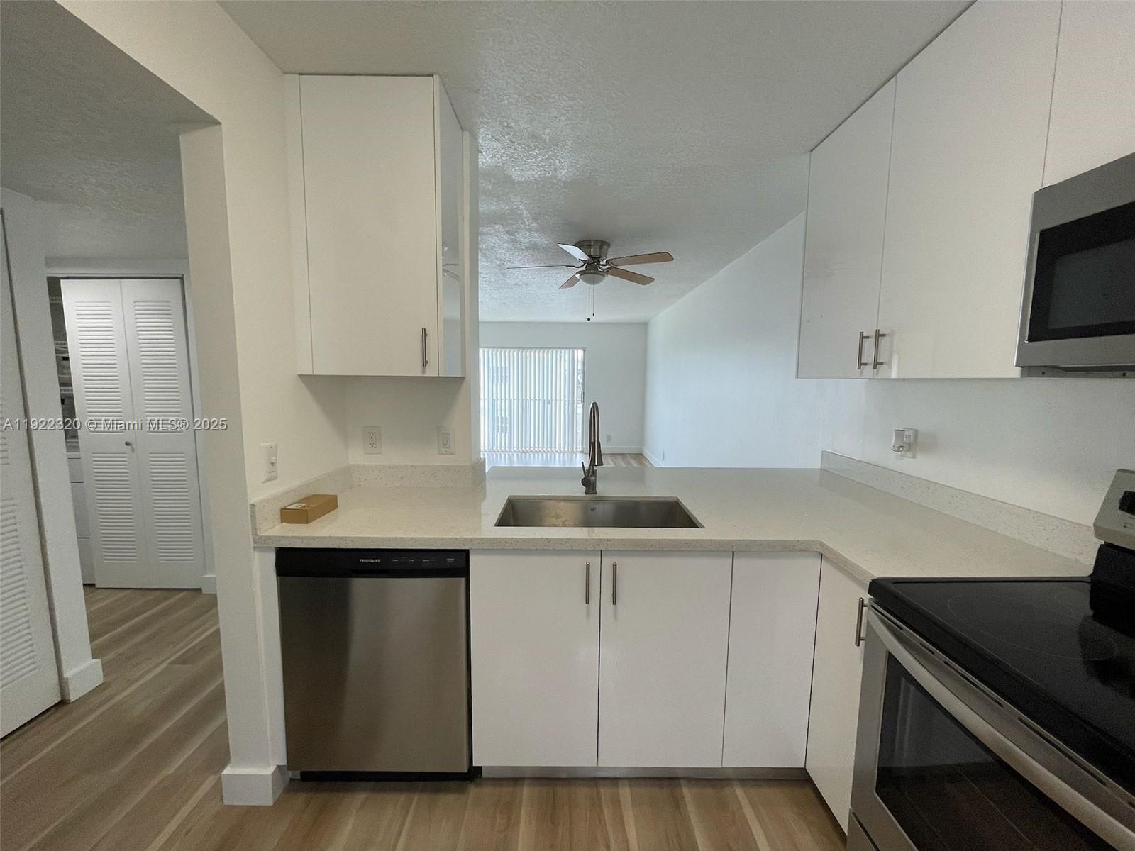 8700 Sherman Circle North, Unit 501 Miramar, FL 33025 - Photo 5 of 14 a kitchen with stainless steel appliances a sink dishwasher stove refrigerator and cabinets