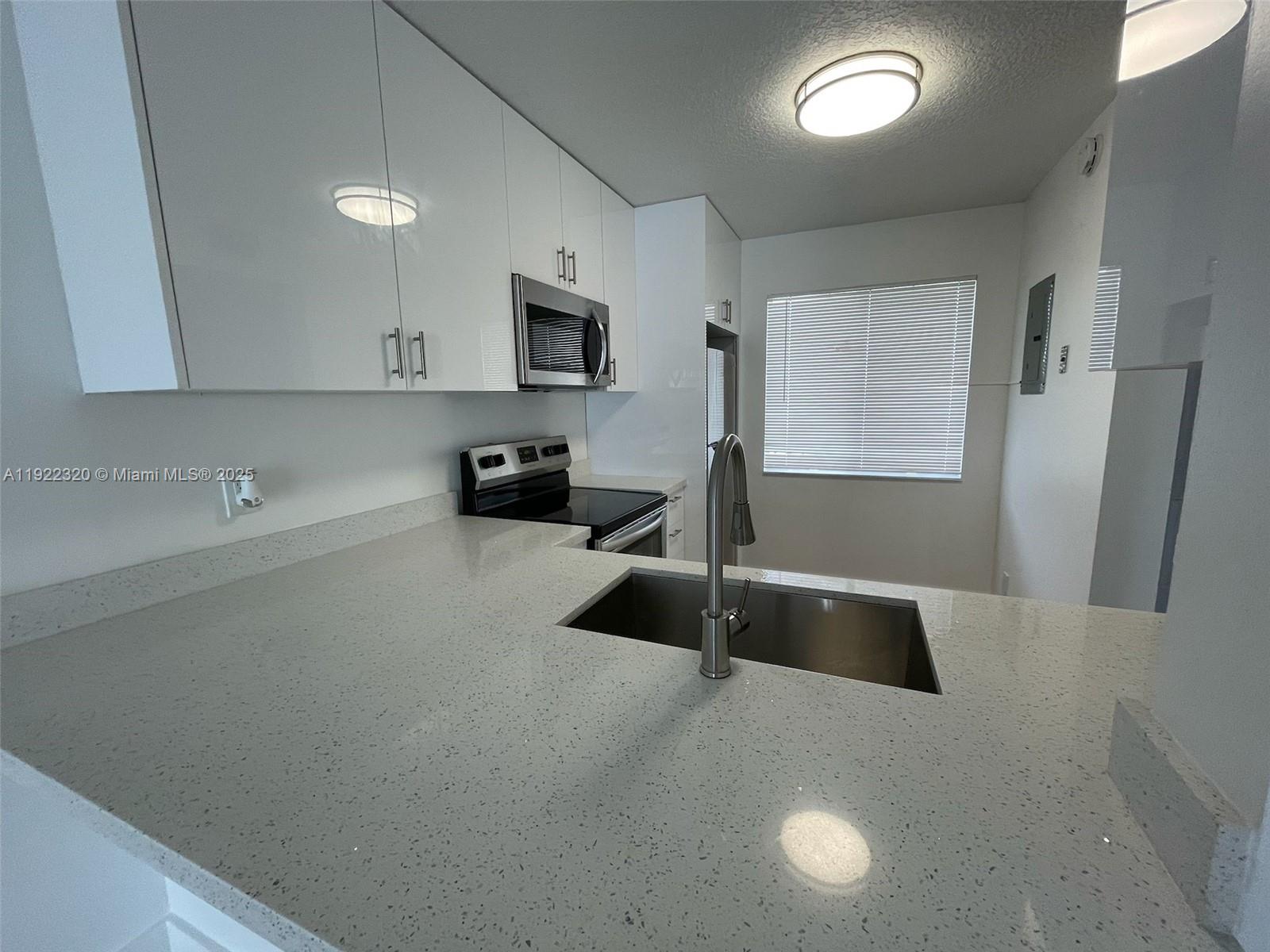 8700 Sherman Circle North, Unit 501 Miramar, FL 33025 - Photo 7 of 14 a kitchen with a sink a stove and a refrigerator