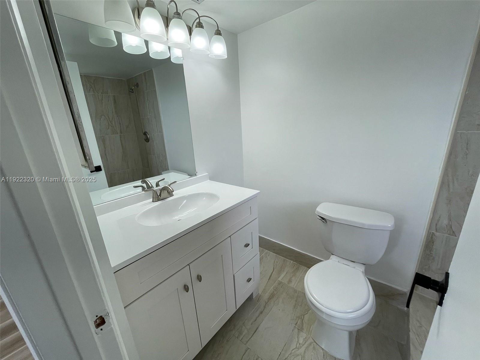8700 Sherman Circle North, Unit 501 Miramar, FL 33025 - Photo 8 of 14 a bathroom with a toilet sink and mirror