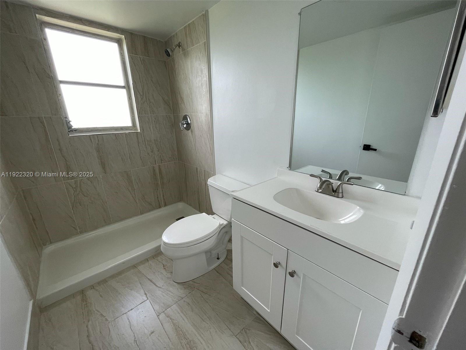 8700 Sherman Circle North, Unit 501 Miramar, FL 33025 - Photo 9 of 14 a bathroom with a sink a toilet and shower