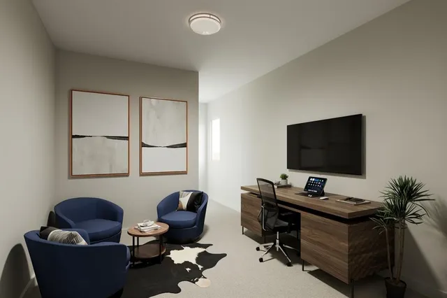 a livingroom with workspace and a couch