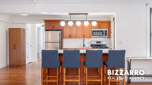 a view of kitchen with stainless steel appliances granite countertop furniture and a refrigerator