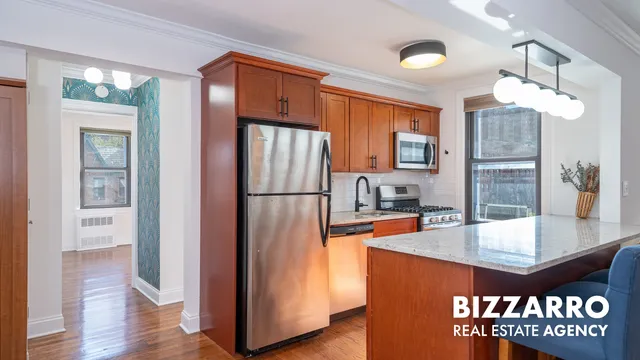 a kitchen with stainless steel appliances granite countertop a refrigerator a sink and a stove with wooden floor