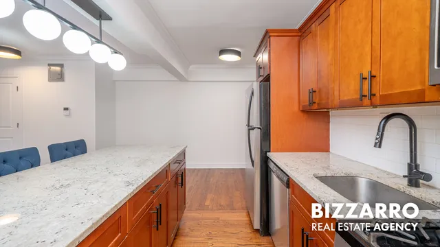 a kitchen with kitchen island granite countertop a sink a counter space and stainless steel appliances