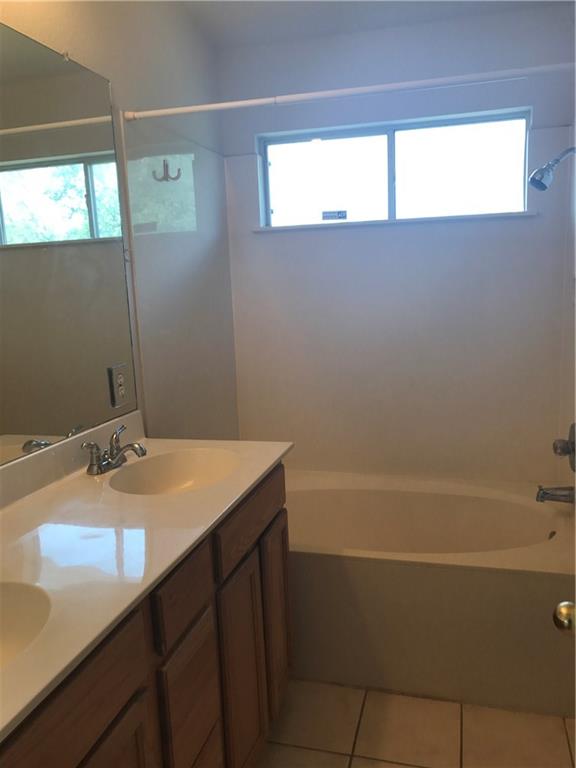 8337 Alvin High Lane Austin, TX 78729 - Photo 13 of 14 Full bath featuring double vanity, shower / bath combination, light tile patterned floors, and healthy amount of natural light