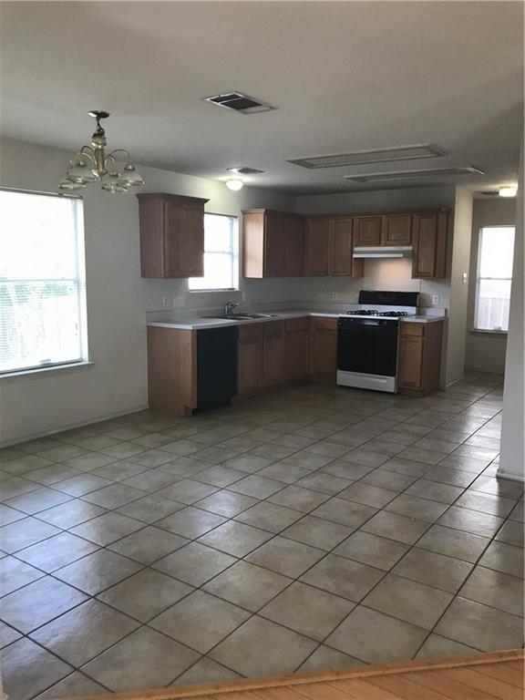 8337 Alvin High Lane Austin, TX 78729 - Photo 4 of 14 Kitchen with white gas range, light countertops, decorative light fixtures, a chandelier, and dishwasher