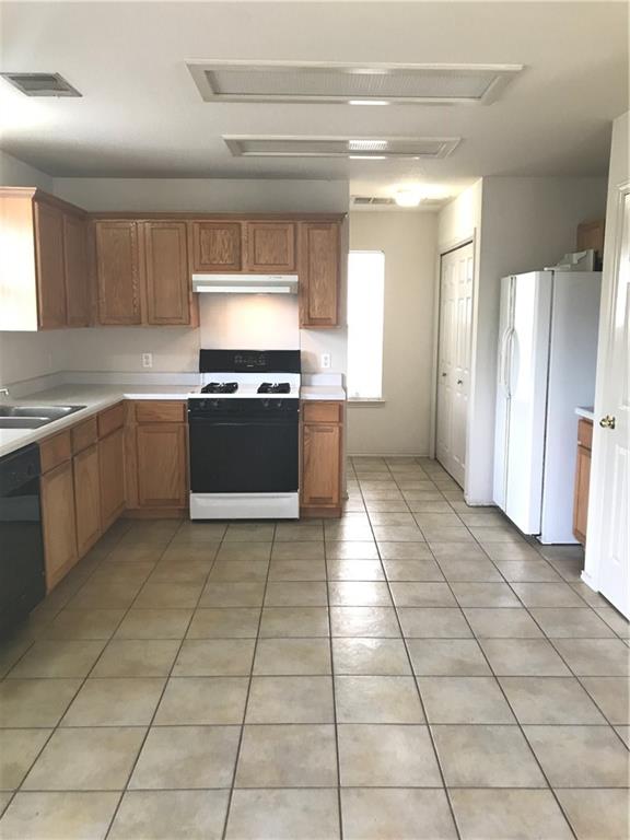 8337 Alvin High Lane Austin, TX 78729 - Photo 5 of 14 Kitchen with white appliances, light countertops, light tile patterned flooring, under cabinet range hood, and brown cabinets