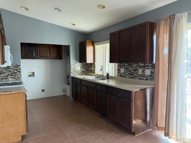 a kitchen with stainless steel appliances granite countertop a stove a sink and a microwave
