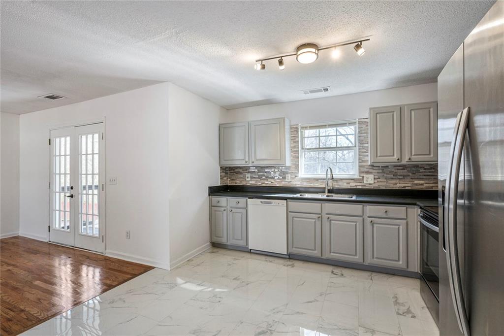 6132 Christopher Terrace Rex, GA 30273 - Photo 13 of 40 a kitchen with granite countertop a sink stainless steel appliances and cabinets