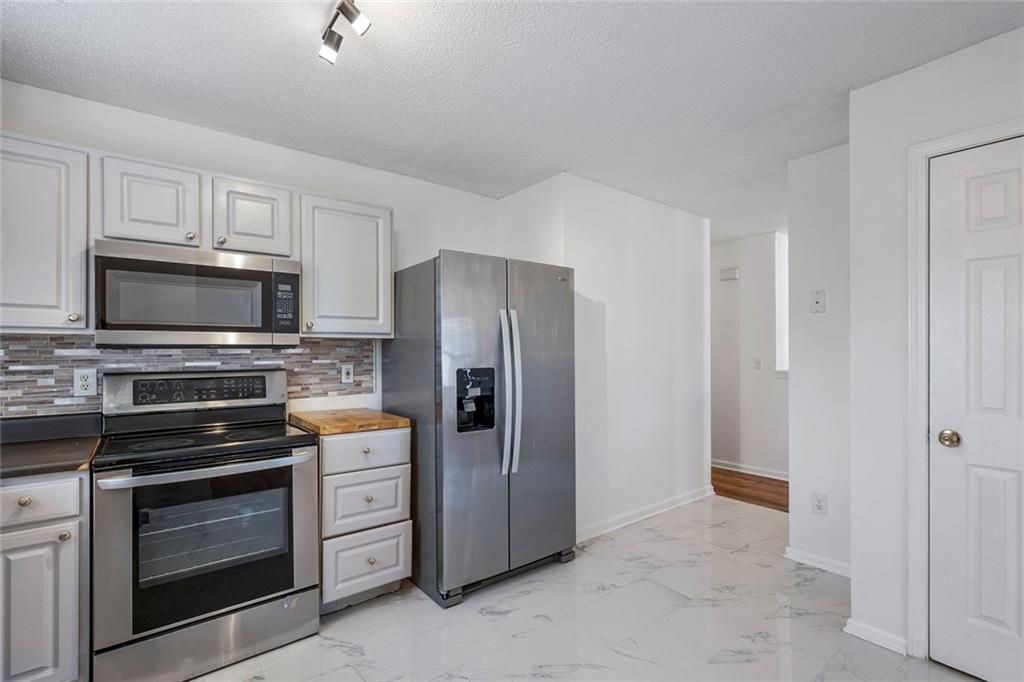 6132 Christopher Terrace Rex, GA 30273 - Photo 15 of 40 a kitchen with white cabinets and stainless steel appliances