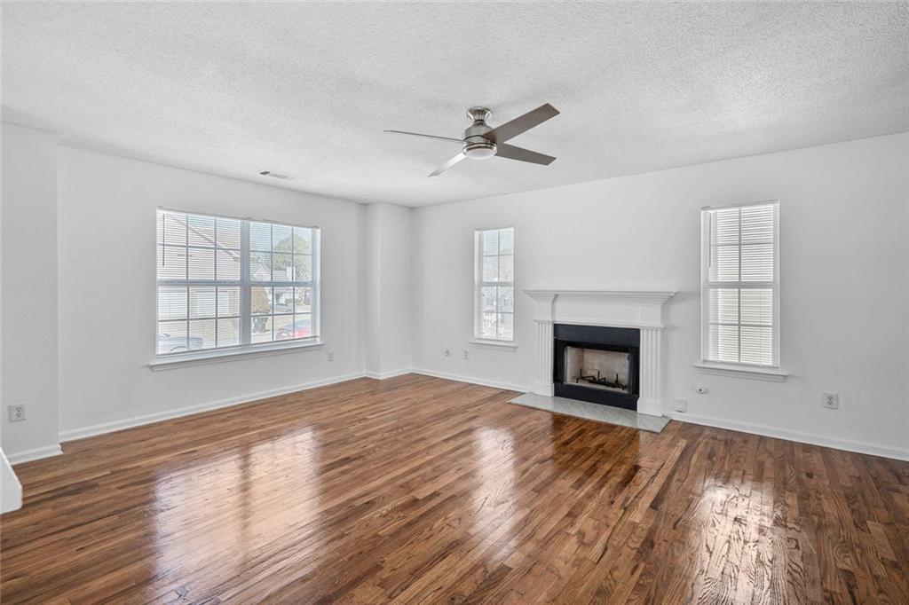 6132 Christopher Terrace Rex, GA 30273 - Photo 2 of 40 an empty room with windows fireplace and wooden floor