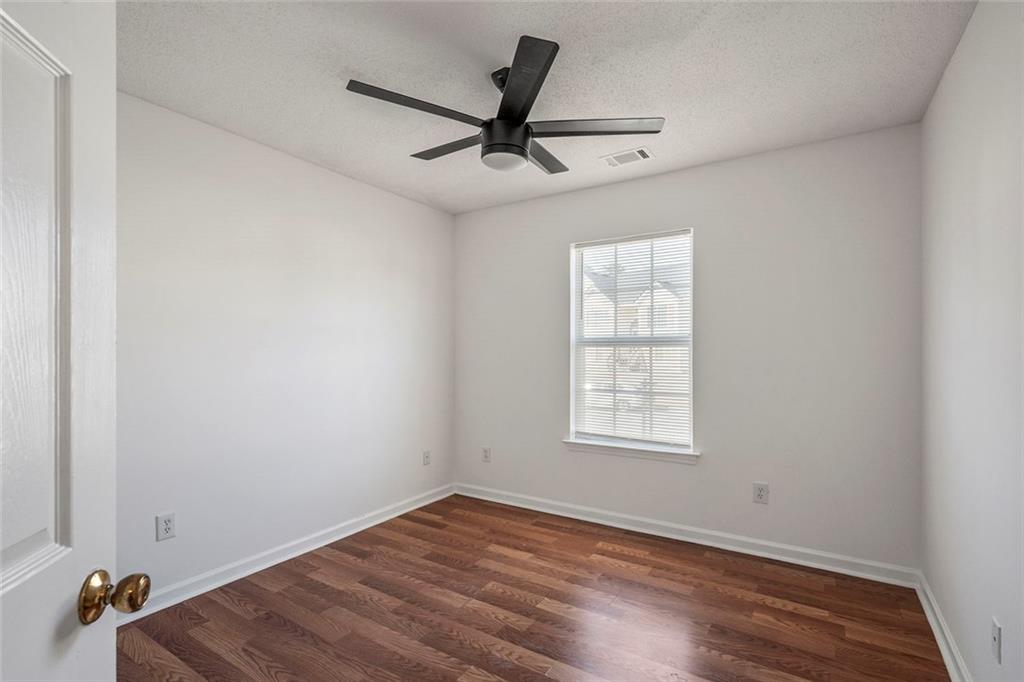 6132 Christopher Terrace Rex, GA 30273 - Photo 22 of 40 an empty room with wooden floor fan and windows