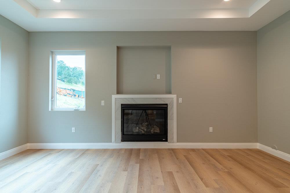 6565 Eagle Ridge Court Gilroy, CA 95020 - Photo 16 of 57 an empty room with wooden floor fireplace and windows