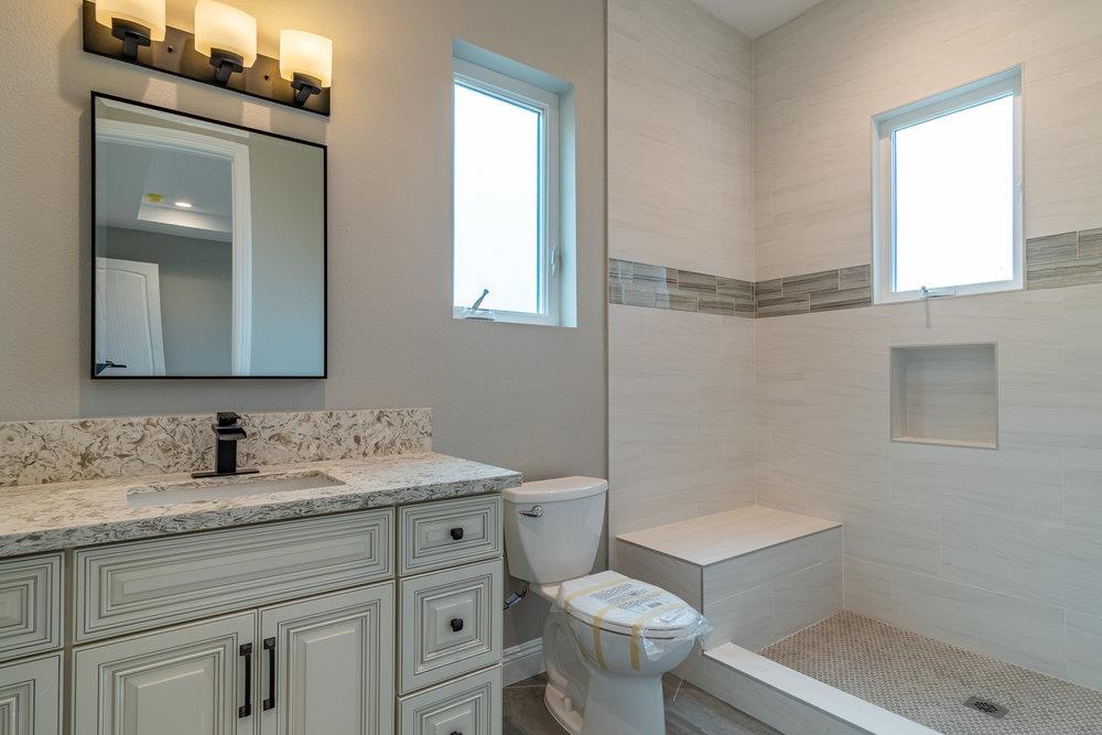 6565 Eagle Ridge Court Gilroy, CA 95020 - Photo 32 of 57 a bathroom with a granite countertop toilet sink and mirror