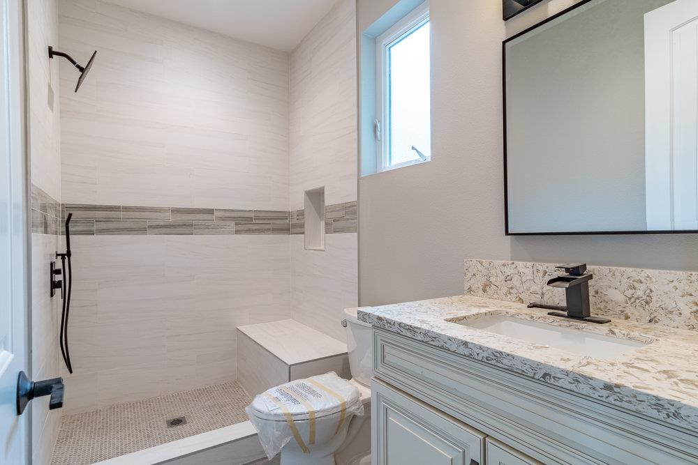 6565 Eagle Ridge Court Gilroy, CA 95020 - Photo 35 of 57 a bathroom with a granite countertop sink a toilet and shower