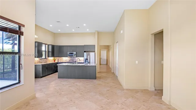 a kitchen with stainless steel appliances a large counter top a stove and a refrigerator