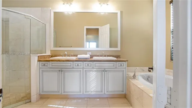 a bathroom with a granite countertop sink a mirror and a bathtub
