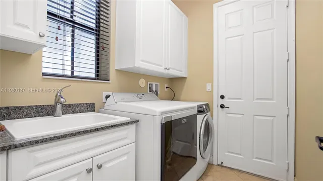 a utility room with faucet washer and dryer