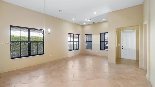 a view of an empty room with glass door and balcony