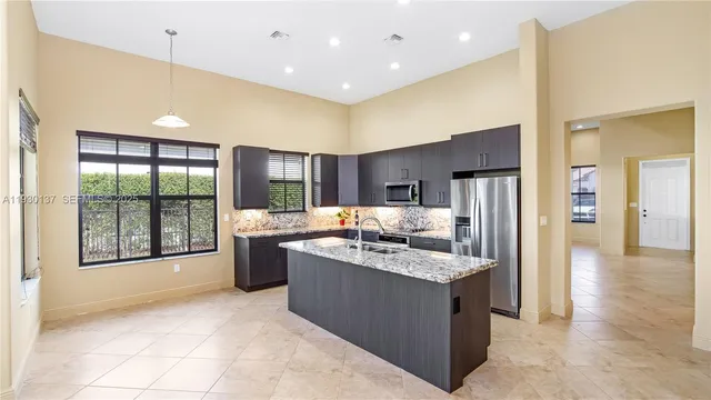 a kitchen with stainless steel appliances granite countertop a refrigerator a sink and a stove