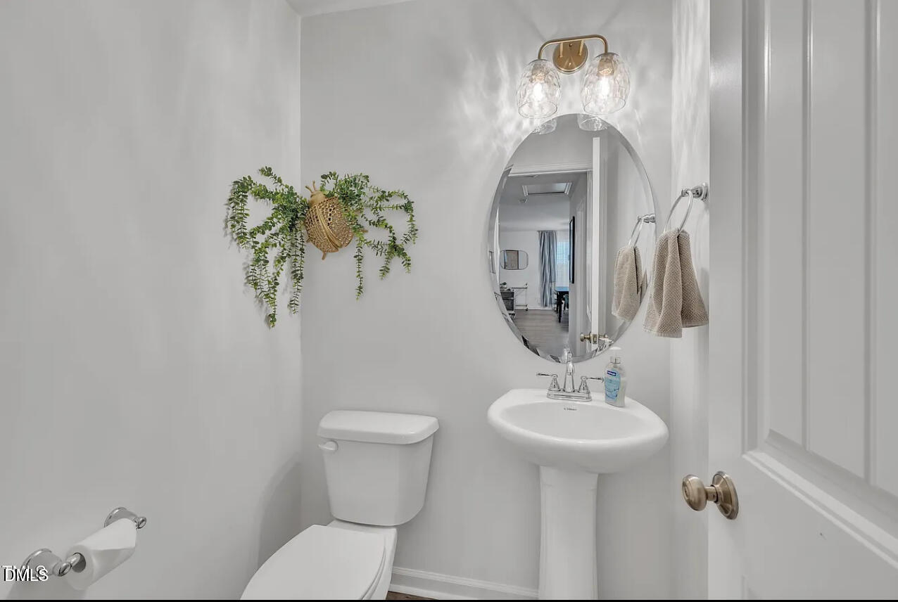 407 Collier Street Smithfield, NC 27577 - Photo 27 of 32 a bathroom with a toilet sink and mirror