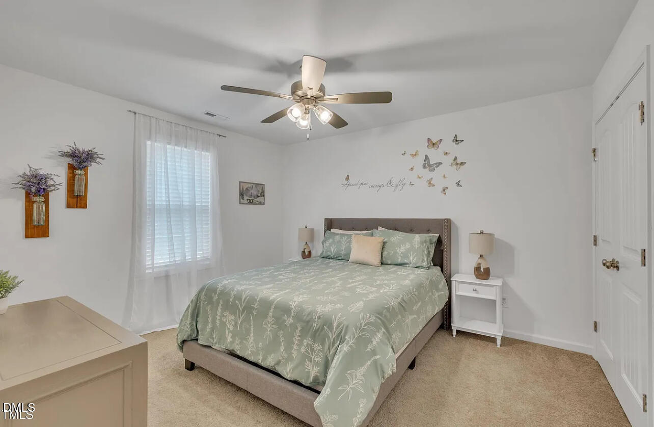 407 Collier Street Smithfield, NC 27577 - Photo 28 of 32 a bedroom with a bed and a chandelier