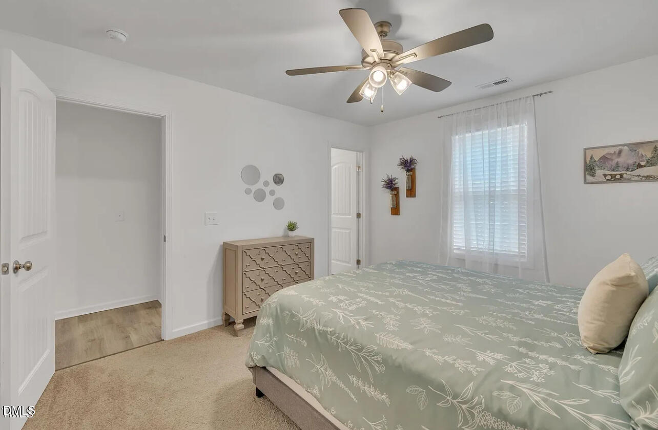 407 Collier Street Smithfield, NC 27577 - Photo 29 of 32 a bedroom with a bed and a chandelier
