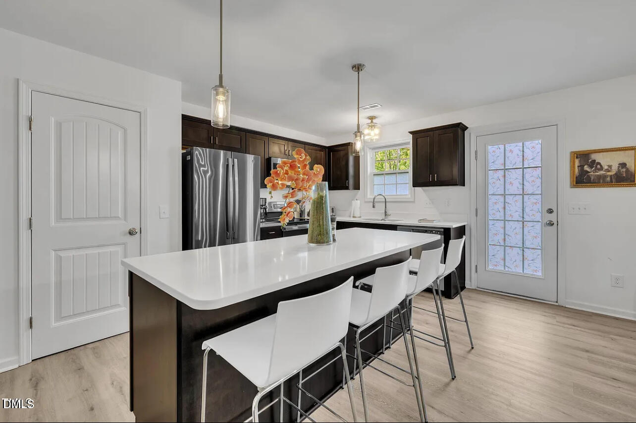 407 Collier Street Smithfield, NC 27577 - Photo 8 of 32 a kitchen with stainless steel appliances a dining table chairs microwave and refrigerator