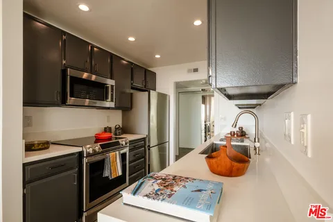 a kitchen with stainless steel appliances granite countertop a sink a stove and a refrigerator