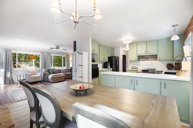 a kitchen with a table chairs stove and refrigerator