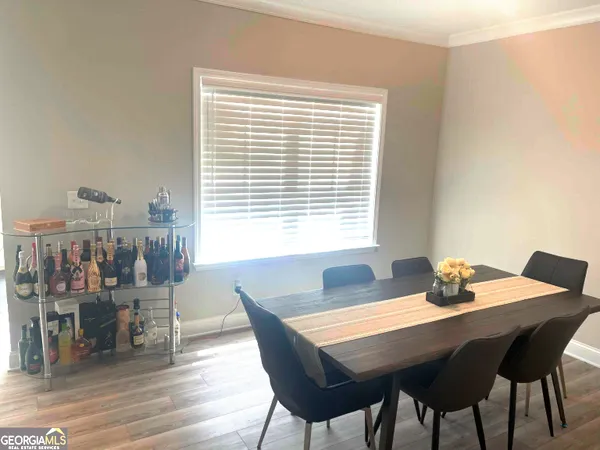 a dining room with furniture and wooden floor