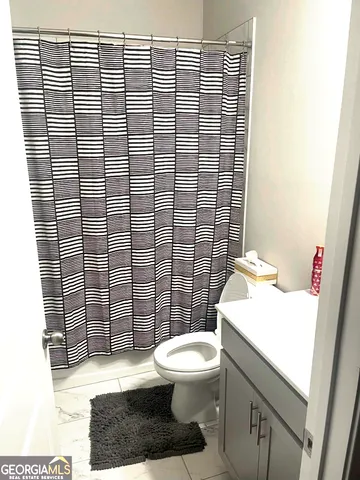 a bathroom with a toilet and a shower