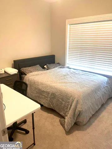 a bedroom with a bed and a window