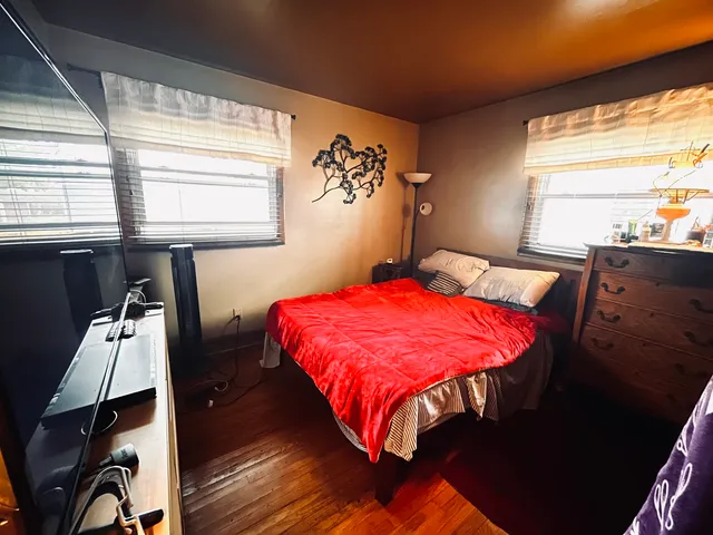 a bedroom with a bed and wooden floor