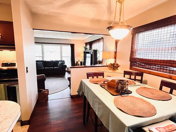 a view of a dining room with furniture a chandelier and wooden floor