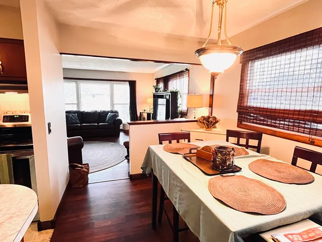 a view of a dining room with furniture a chandelier and wooden floor