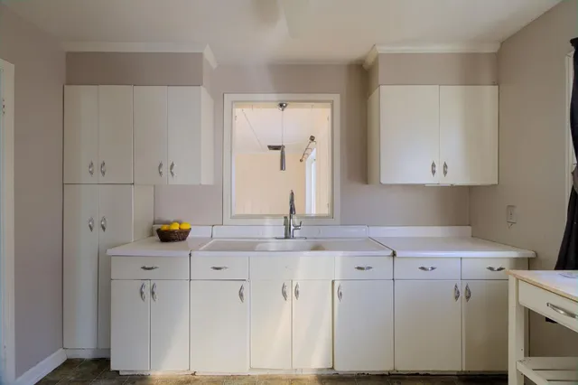 a view of cabinets a sink and dishwasher with wooden floor