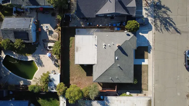 an aerial view of a house with garden space and sitting area