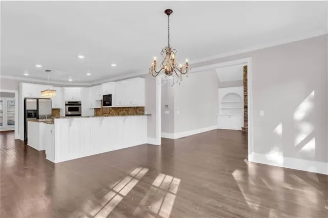 a view of a kitchen with kitchen island a chandelier and wooden floor
