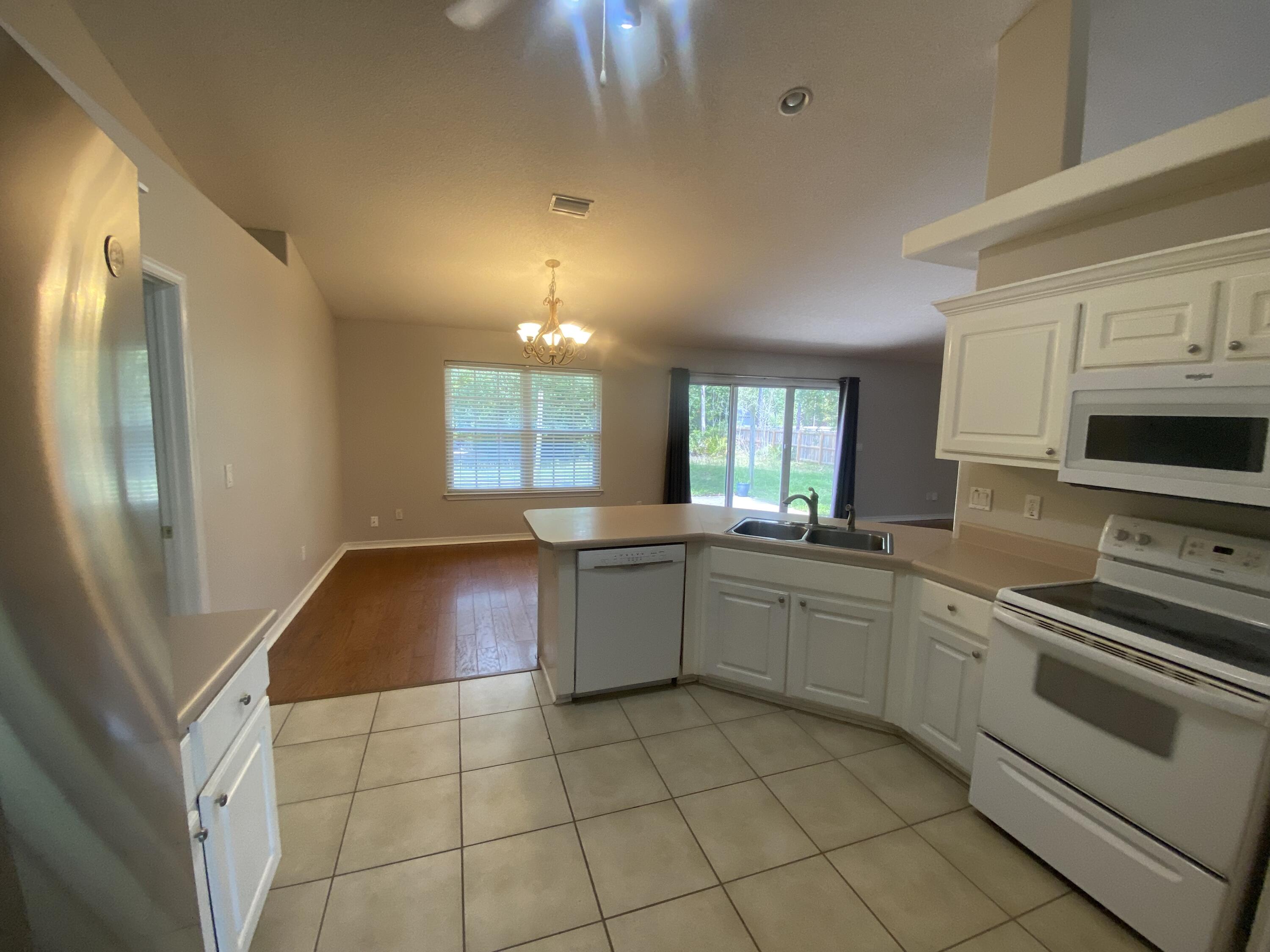 6568 Fern Street Navarre, FL 32566 - Photo 4 of 10 a kitchen with a sink cabinets and stainless steel appliances