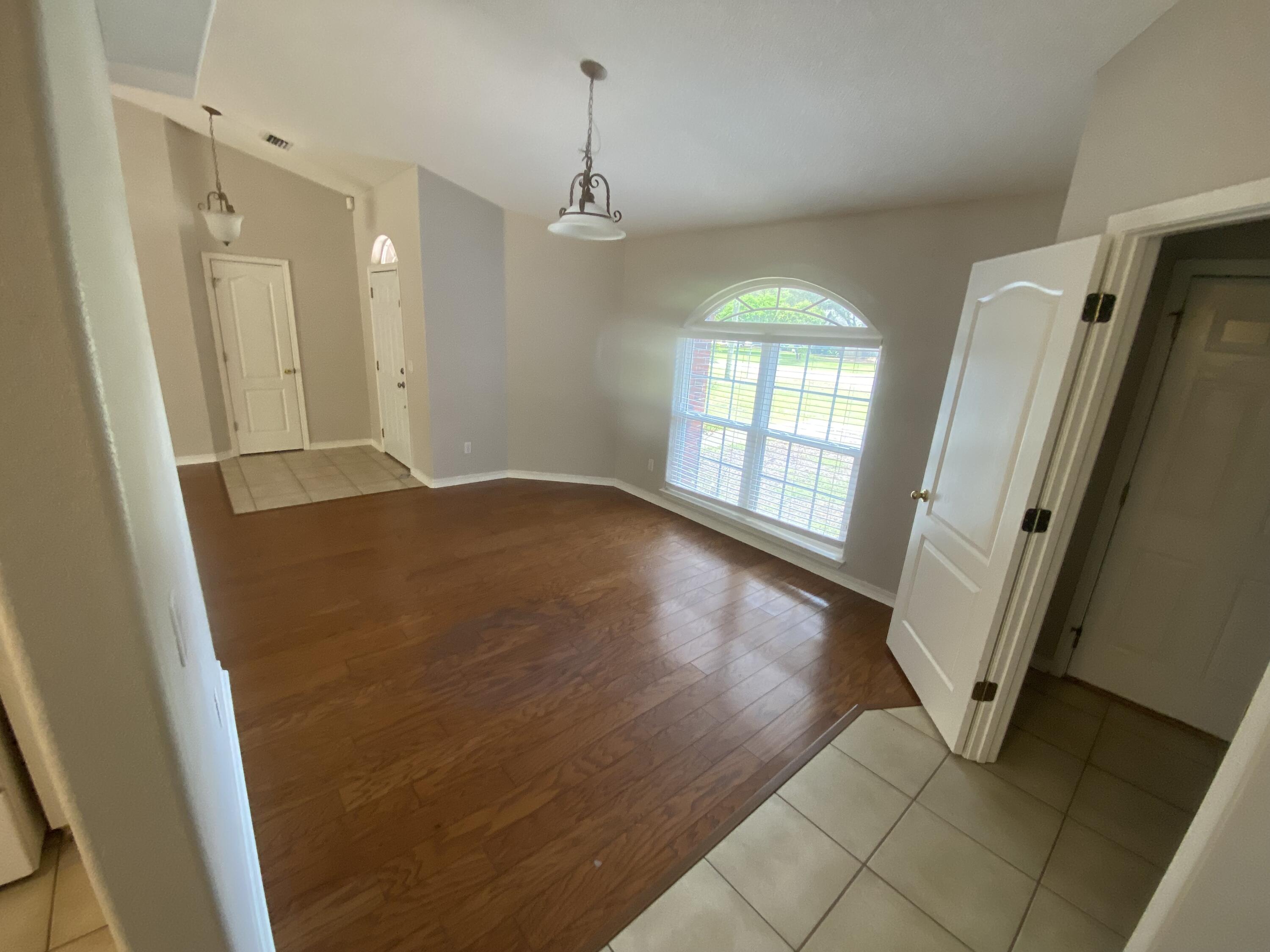 6568 Fern Street Navarre, FL 32566 - Photo 6 of 10 wooden floor in an empty room with a window