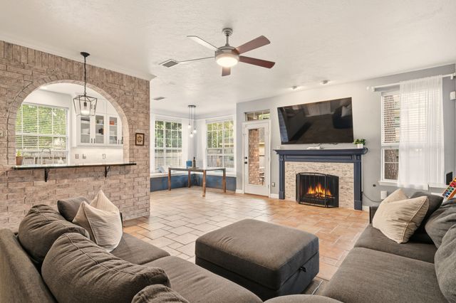 a living room with furniture a fireplace and a flat screen tv