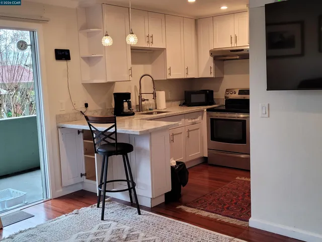 a kitchen with stainless steel appliances kitchen island granite countertop a stove a sink and a microwave